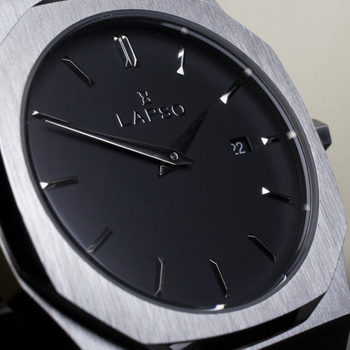 Reloj plateado con 2 manecillas y dial negro con fecha
