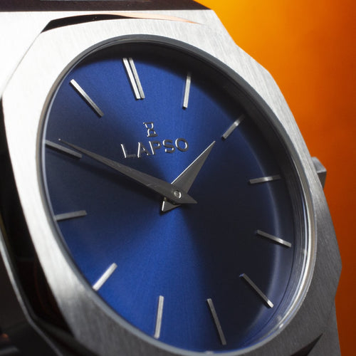 Reloj plateado con 2 manecillas y dial azul