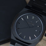 Reloj negro con 3 manecillas negras y dial negro con fecha