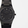 Reloj negro con 3 manecillas negras y dial negro con fecha