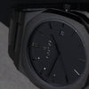 Reloj negro con 3 manecillas negras y dial negro con fecha