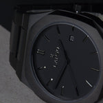 Reloj negro con 3 manecillas negras y dial negro con fecha
