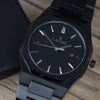 Reloj negro con 3 manecillas plateadas y dial negro con fecha