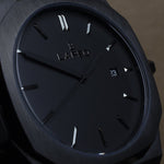 Reloj negro con 3 manecillas negras y dial negro con fecha