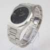 Reloj plateado con 2 manecillas y dial negro con fecha