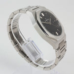 Reloj plateado con 3 manecillas y dial negro con fecha
