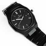 Reloj negro con 3 manecillas plateadas y dial negro con fecha